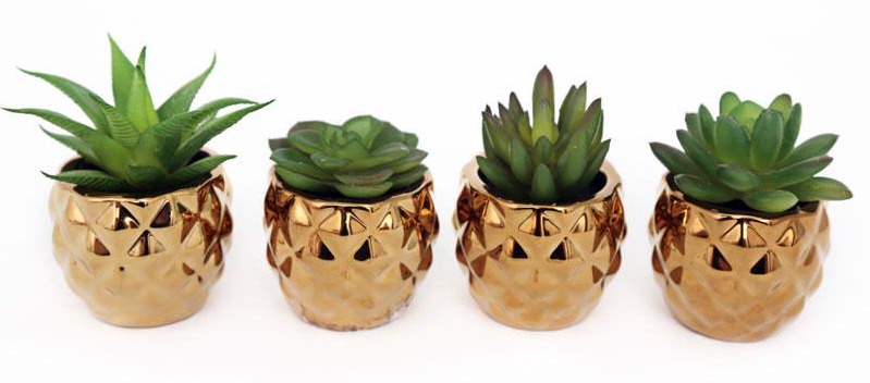 A row of artificial plants in gold pots